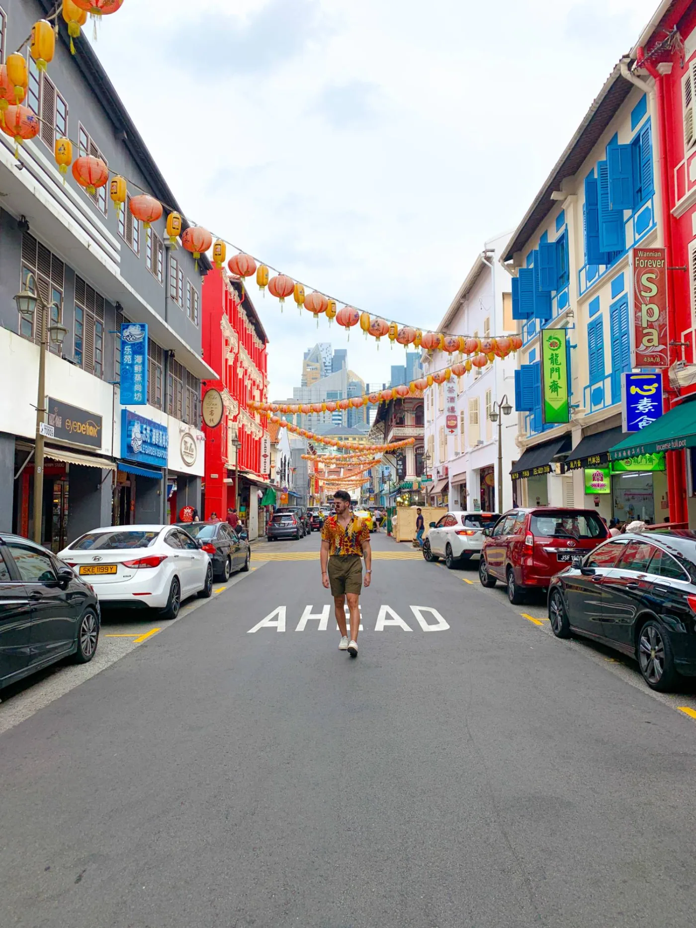 Walter walking up a Chinatown street in Singapore, lanterns strung overhead