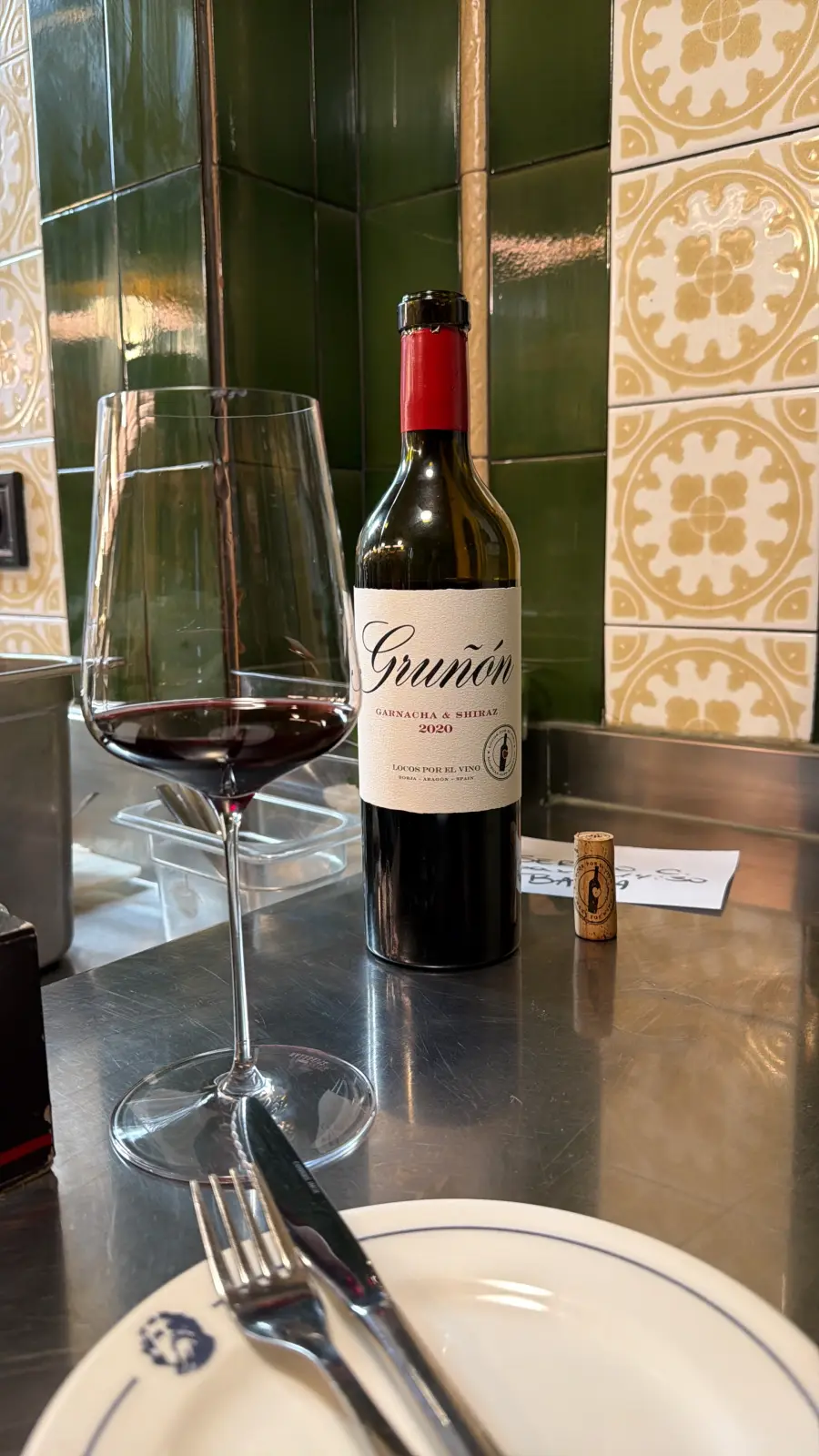 A glass of red wine on the counter at Ultramarinos Marín