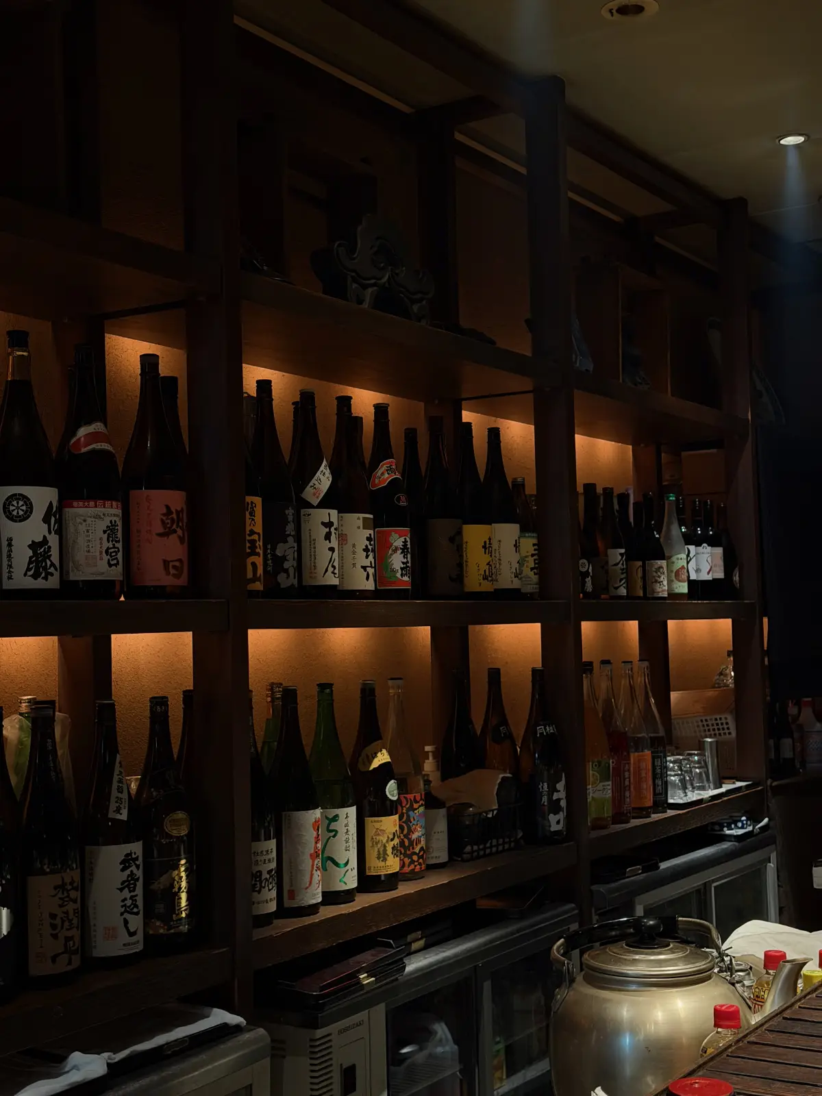 Sake bottles on the shelves at Negiya Heikichi