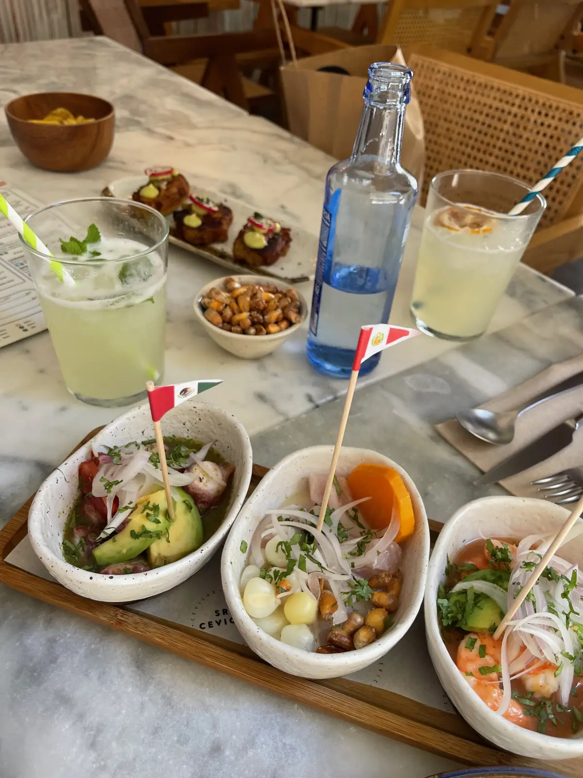 A table of ceviche and drinks at Sr. Ceviche